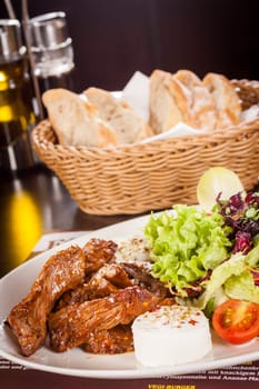 Fresh salad with fresh goat cheese and fried beef strips served on a plate