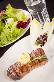 Succulent grilled beef fillet steak with homemade herb butter on a plate