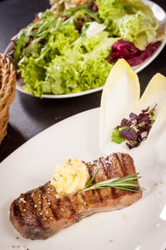 Succulent grilled beef fillet steak with homemade herb butter on a plate