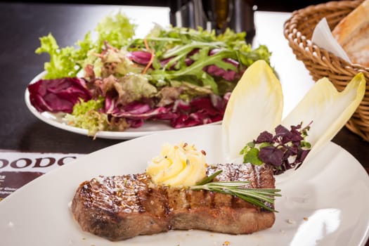 Succulent grilled beef fillet steak with homemade herb butter on a plate