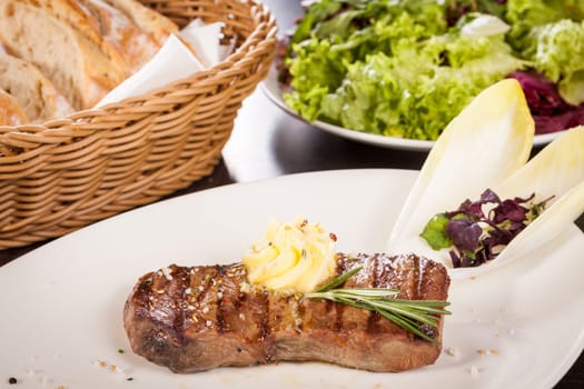 Succulent grilled beef fillet steak with homemade herb butter on a plate