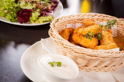 Fresh chicken flails and nuggets golden fried in a basket