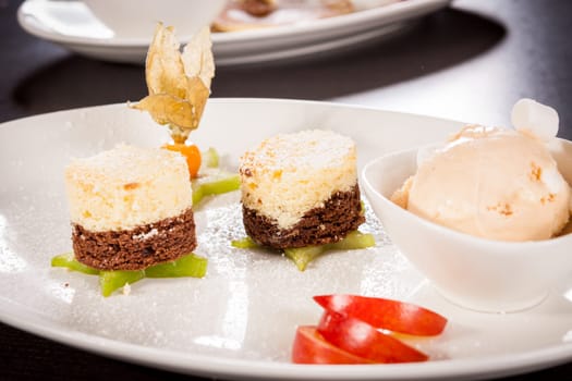 Brownie chocolate brownie with ice cream and plums prepared on a plate