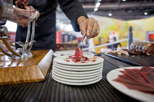 Waiter serving acorn-fed Iberian ham, Spain