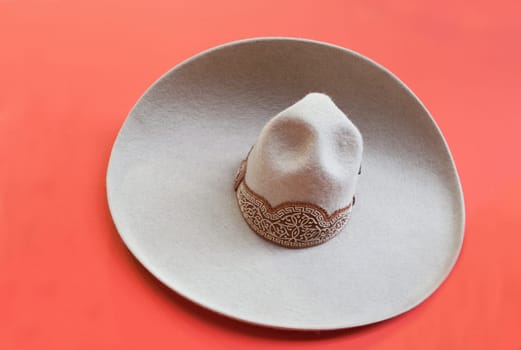 Mexican style bullfighter grey hat, isolated over red background