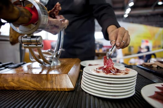 Waiter serving acorn-fed Iberian ham, Spain