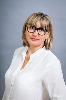 attractive adult woman in middle age with white blouse and brille