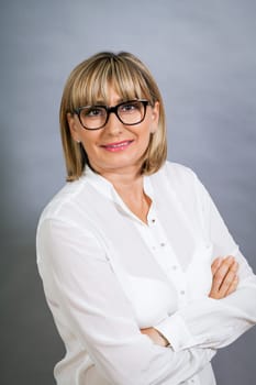 attractive adult woman in middle age with white blouse and brille