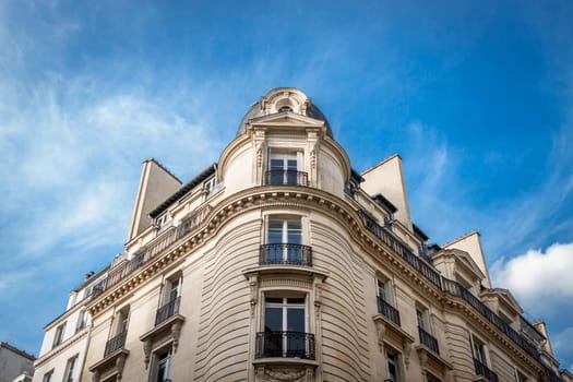 Exterior view of a Parisian townhouse in summer in front of a blue sky