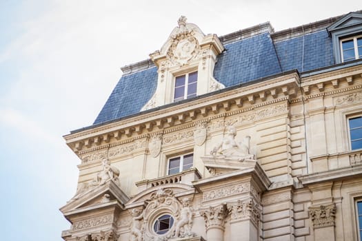 Exterior view of a Parisian townhouse in summer in front of a blue sky