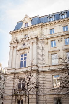 Exterior view of a Parisian townhouse in summer in front of a blue sky