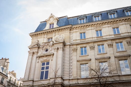 Exterior view of a Parisian townhouse in summer in front of a blue sky