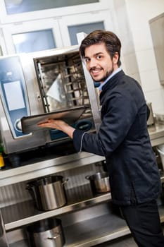 young adult chef in the restaurant kitchen while cooking at the herd preparation