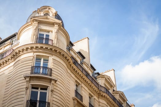 Exterior view of a Parisian townhouse in summer in front of a blue sky