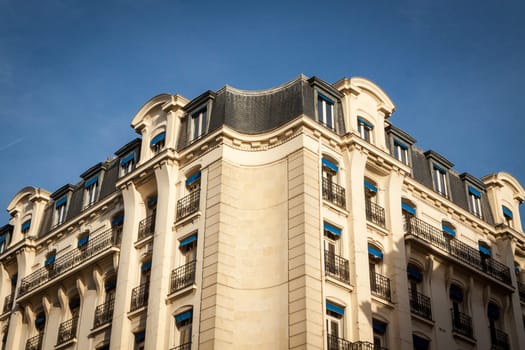 Exterior view of a Parisian townhouse in summer in front of a blue sky