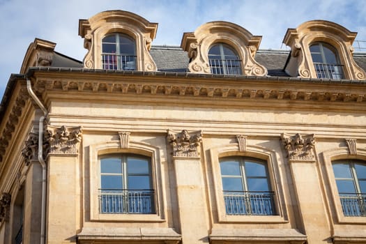 Exterior view of a Parisian townhouse in summer in front of a blue sky