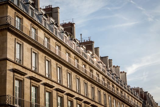 Exterior view of a Parisian townhouse in summer in front of a blue sky