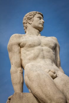 Statue of stone marble carved in front of blue sky in Paris
