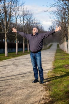 Man middle Altres pensioner with outstretched arms enjoys the fresh air