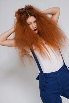 Young attractive pretty woman with long red hair and ripped hairstyle in portrait