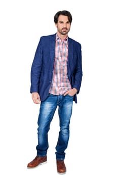 Young man in trendy casual look with dark hair and beard isolated against a white background