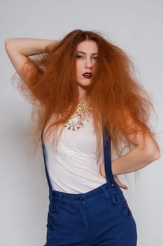 Young attractive pretty woman with long red hair and ripped hairstyle in portrait