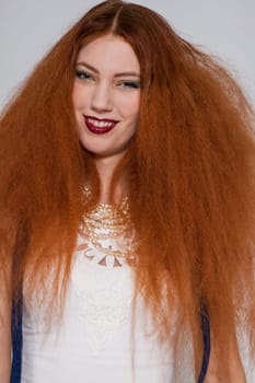 Young attractive pretty woman with long red hair and ripped hairstyle in portrait