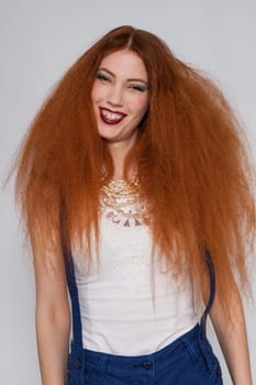 Young attractive pretty woman with long red hair and ripped hairstyle in portrait