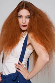 Young attractive pretty woman with long red hair and ripped hairstyle in portrait