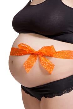 Young pregnant woman with orange bow around her belly as close-up isolated against white background