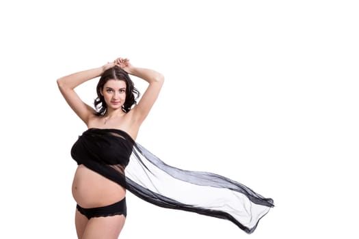 Young attractive pregnant woman wrapped in black fabric insulated against white background