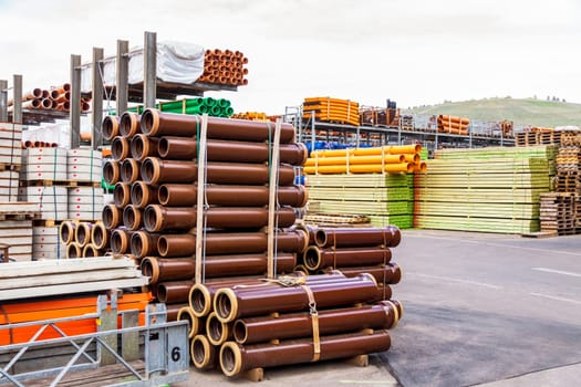 Different pipes for industry stacked in one warehouse in the open air