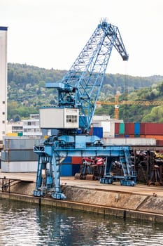 Dock in the port with stacked containers at the dock for import and export cargo with blue sky