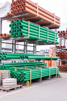 Pipes sewage pipes stacked in green and red in a warehouse