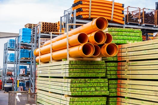 Different pipes for industry stacked in one warehouse in the open air