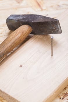 hammer with nails on a wooden board in a workshop of a handyman