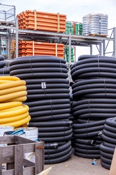 Rolled yellow and black plastic rubber hoses stored in industrial area
