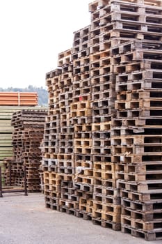 Large stacks of wooden Euro pallets in the industrial area for the packaging of goods