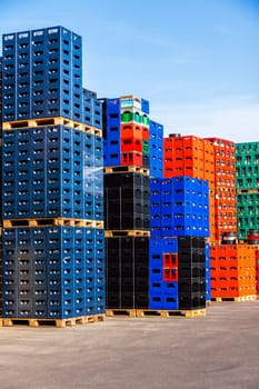 Several stacks of colorful beverage bottle crates outdoors