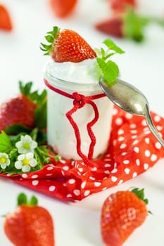 Fresh yoghurt with strawberries in a glass insulated on a white background