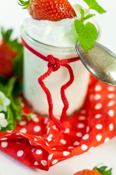 Fresh yoghurt with strawberries in a glass insulated on a white background