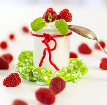 Fresh yoghurt with raspberries in a glass insulated on a white background