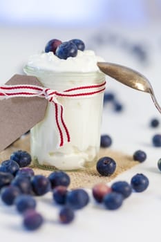 Glass with yoghurt and fresh blueberries blueberries for breakfast and for dessert