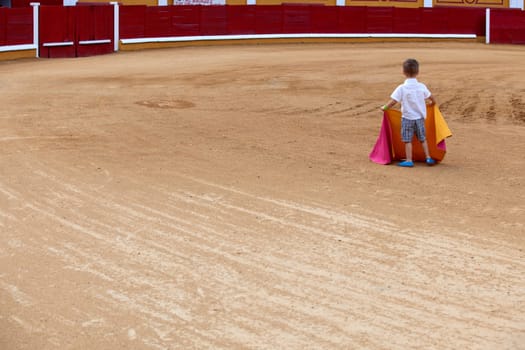 Unidentified child on arena pretending performs a bullfight,  Badajoz, Spain