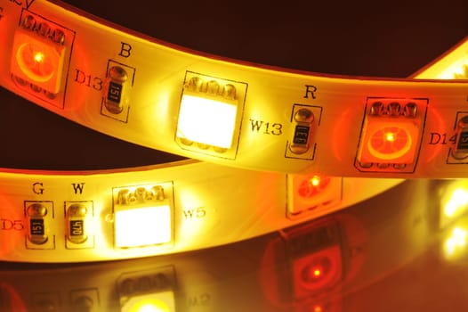 Macrodetail of an RGB LED strip combined with warm white LEDs in colored light