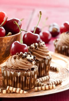 Chocolate cupcakes with buttercream and fresh cherries