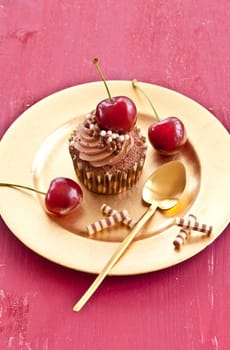 Chocolate cupcake with buttercream and fresh cherries