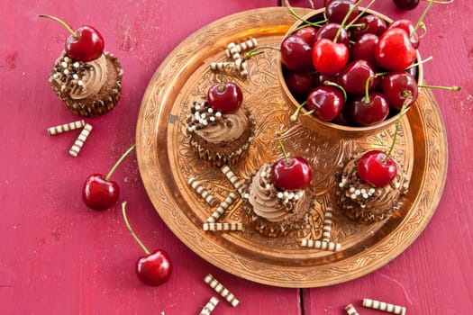 Chocolate cupcakes with buttercream and fresh cherries