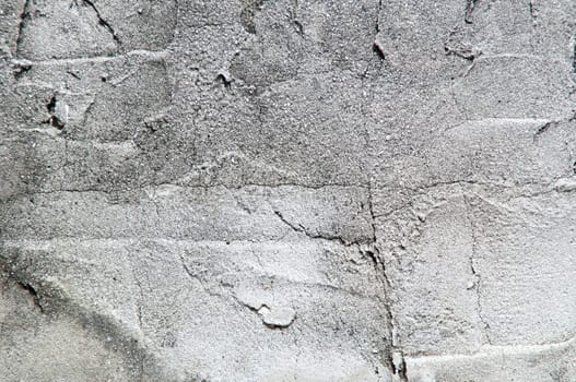 Close up of old textured cement wall in sunshine.