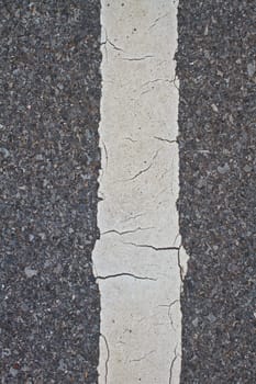 asphalt road with marking lines and tire tracks. Close up photo with selective focus